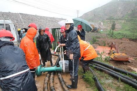 圖一為中州鋁業(yè)保障中心員工冒雨在現(xiàn)場搬運潛水泵設備，以應對未來幾天更加嚴峻的汛情。